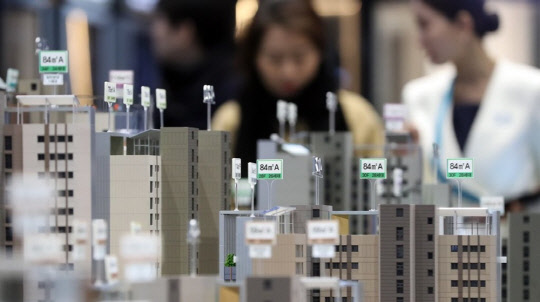 정부가 다음달 18일부터 저소득층을 대상으로 내 집 마련 및 전세 자금 대출 금리를 0.2∼0.25% 낮춘다. 서울 지역의 새 아파트 견본주택에서 시민들이 아파트 배치를 살펴보고 있다.<연합뉴스>